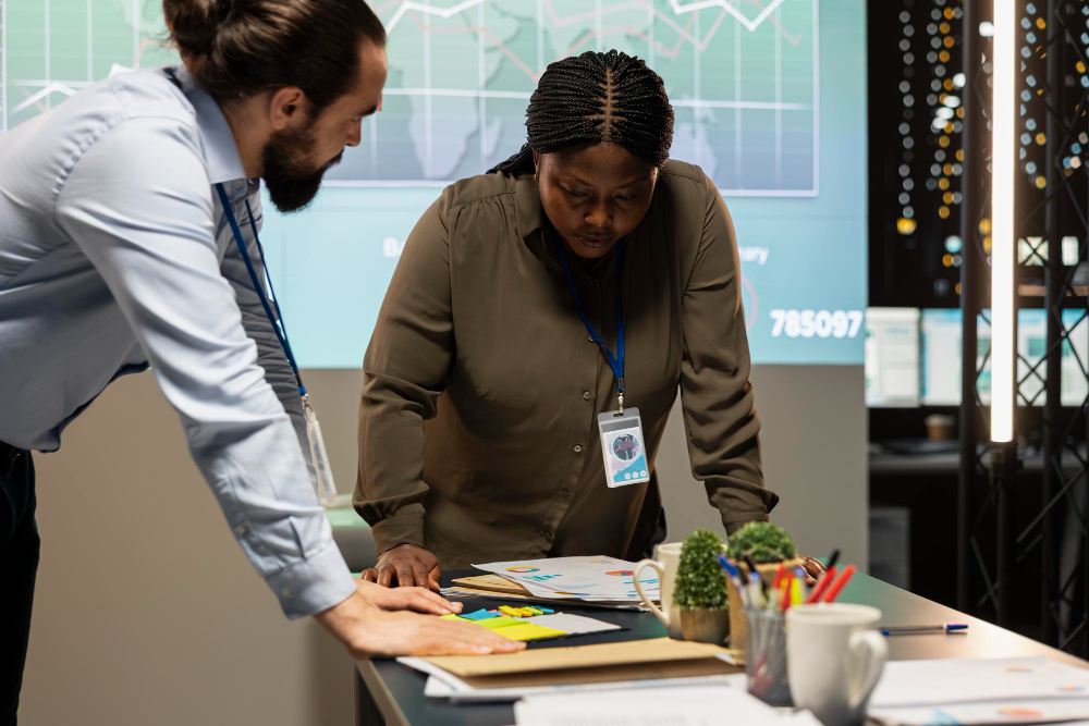 Multiethnic team reviewing analytics in a late night company briefing