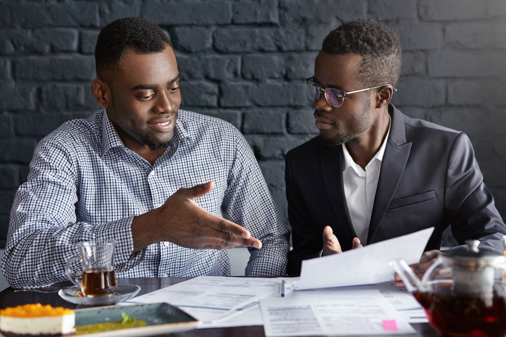 Attractive african businessman in glasses and suit holding papers